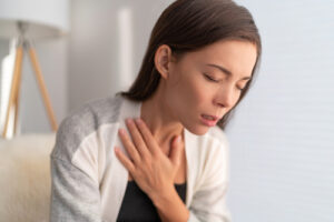 Asian girl in pain touching chest respiratory symptoms